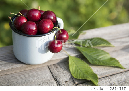 Fresh sweet cherries bowl with leaves Fresh sweet cherries bowl with leaves 42874537