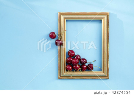 Fresh sweet cherries in frame on blue background 42874554