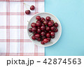 Fresh sweet cherries bowl, napkin on blue background 42874563