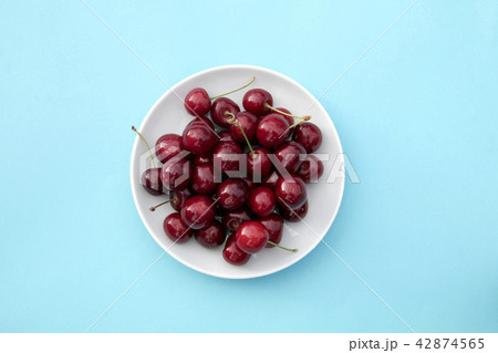 Fresh sweet cherries bowl on blue background 42874565