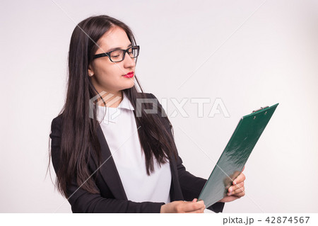 Young business woman wearing glasses, holding paper folder on white background 42874567