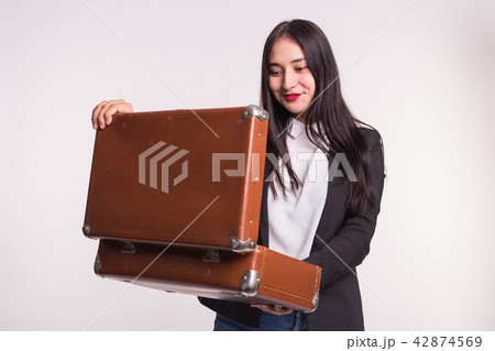 Beautiful asian girl with red lips staring into retro suitcase. 42874569