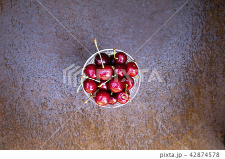 Fresh sweet cherries bowl on grunge rust background 42874578