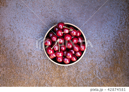 Fresh sweet cherries bowl on grunge rust background 42874581