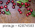 Fresh sweet cherries bowl with leaves on grunge rust background 42874583