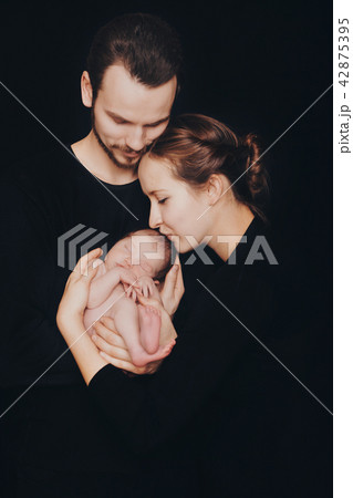 newborn baby lying on the hands of parents 42875395