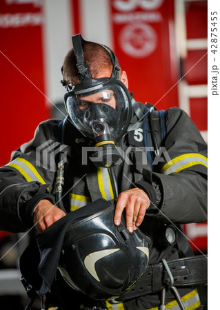 Photo of fireman wearing gas mask near fire engine 42875455