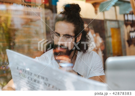 Serious thoughtful man reading an article Serious thoughtful man reading an article 42878383
