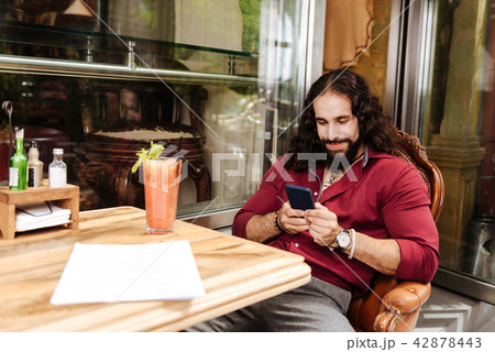 Delighted nice man using his smartphone 42878443