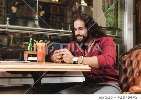 Joyful positive man typing a message Joyful positive man typing a message 42878445