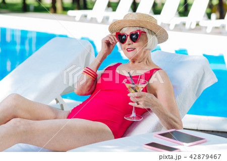 Stylish modern grandmother having rest lying on chase lounge 42879467