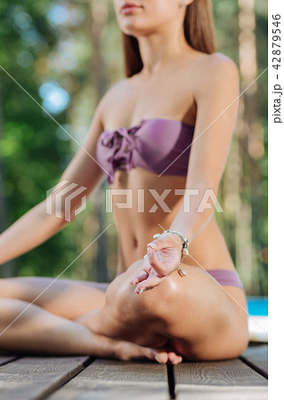 Stylish athletic woman meditating sitting in nature 42879546