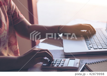 close up woman using calculator and laptop on close up woman using calculator and laptop on 42879998