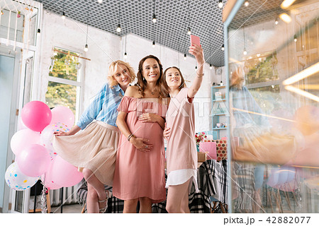 Dark-haired woman making selfie with her pregnant sister 42882077