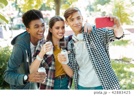 Modern beaming students making selfie together Modern beaming students making selfie together 42883425