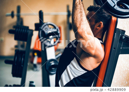 Athlete does deltoid exercises on hammer machine Athlete does deltoid exercises on hammer machine 42889909