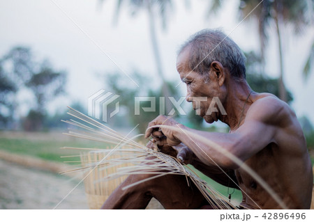 Old man are weaving bamboo wood. 42896496