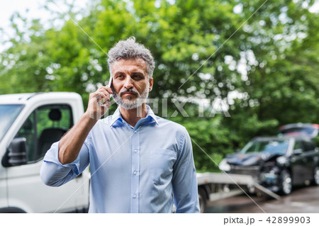 Mature man making a phone call after a car accident. Copy space. Mature man making a phone call after a car accident. Copy space. 42899903
