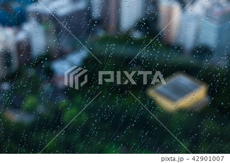高層階の雨粒 窓越しにぼんやりと浮かぶ街 c 公園の緑 高層階の雨粒 窓越しにぼんやりと浮かぶ街 c 公園の緑 42901007