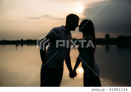 Silhouette of beautiful couple. lake in background 42901234