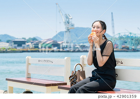 ベンチでアイスモナカを食べる女性 ベンチでアイスモナカを食べる女性 42901359