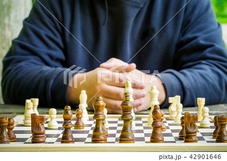 Man sitting near chessboard at outdoor Man sitting near chessboard at outdoor 42901646