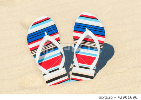 Flip flops in sand near sea 42901696