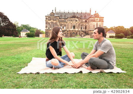 Young couple sitting in front of Historic Building Young couple sitting in front of Historic Building 42902634