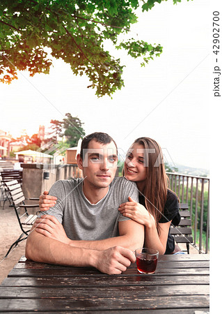 Young beautiful couple share tea at garden table 42902700