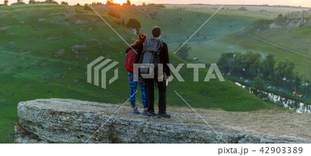 Photo from back of hugging young couple of tourists on mountain 42903389