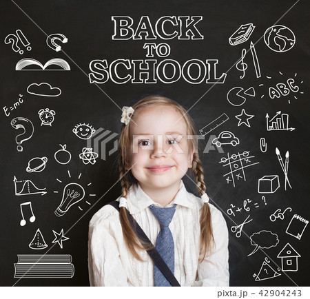 Happy pupil little girl in classroom on blackboard 42904243