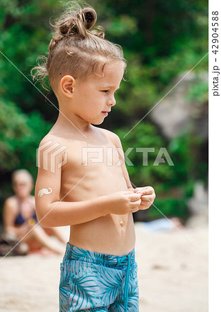 little serious boy standing on the beach 42904588