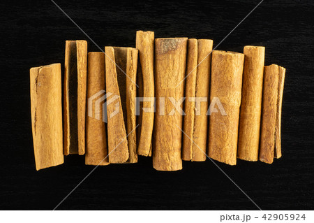 Dry brown cinnamon stick on black wood Dry brown cinnamon stick on black wood 42905924