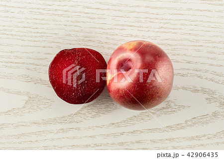 Fresh pluot interspecific plums on grey wood Fresh pluot interspecific plums on grey wood 42906435