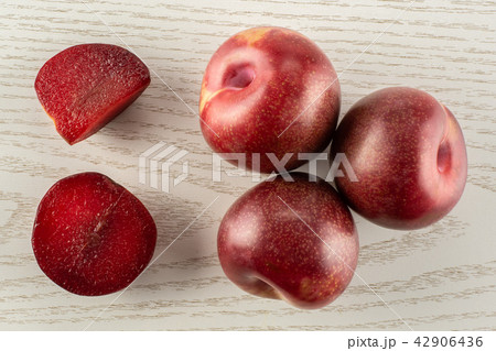 Fresh pluot interspecific plums on grey wood 42906436