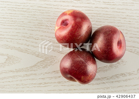Fresh pluot interspecific plums on grey wood 42906437