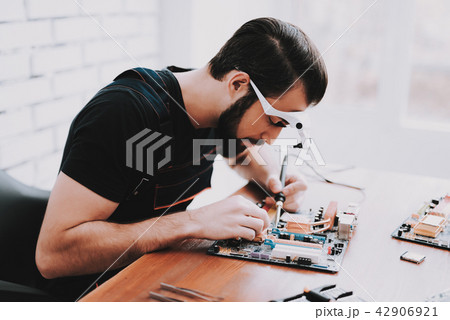 Young Bearded Man Repairing Motherboard from PC. 42906921