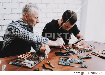 Two Men Repairing Hardware Equipment from PC. Two Men Repairing Hardware Equipment from PC. 42906923