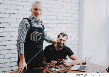 Two Men Repairing Hardware Equipment in Workshop. Two Men Repairing Hardware Equipment in Workshop. 42907038