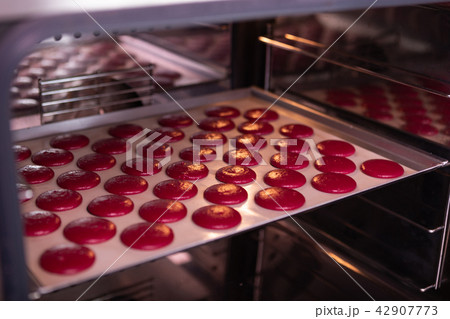 Little bright pink round biscuits standing in the oven Little bright pink round biscuits standing in the oven 42907773