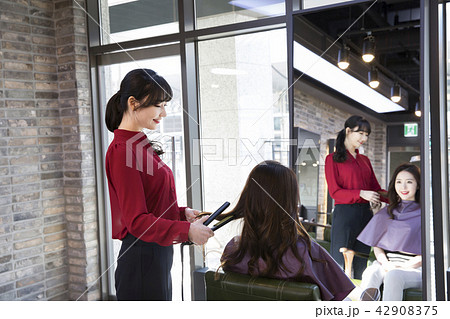 Hairdresser styling woman's hair in a salon. Korean beauty stock photo. 118 Hairdresser styling woman's hair in a salon. Korean beauty stock photo. 118 42908375