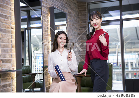 Hairdresser styling woman's hair in a salon. Korean beauty stock photo. 142 Hairdresser styling woman's hair in a salon. Korean beauty stock photo. 142 42908388