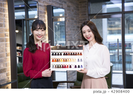 Hairdresser styling woman's hair in a salon. Korean beauty stock photo. 150 Hairdresser styling woman's hair in a salon. Korean beauty stock photo. 150 42908400