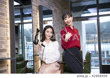 Hairdresser styling woman's hair in a salon. Korean beauty stock photo. 139 Hairdresser styling woman's hair in a salon. Korean beauty stock photo. 139 42908409