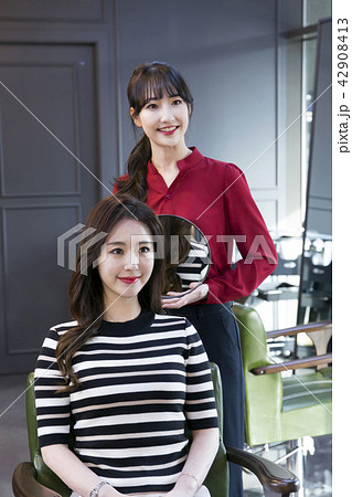 Hairdresser styling woman's hair in a salon. Korean beauty stock photo. 105 42908413