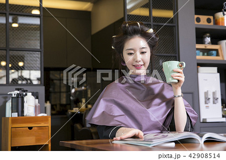 Hairdresser styling woman's hair in a salon. Korean beauty stock photo. 085 Hairdresser styling woman's hair in a salon. Korean beauty stock photo. 085 42908514