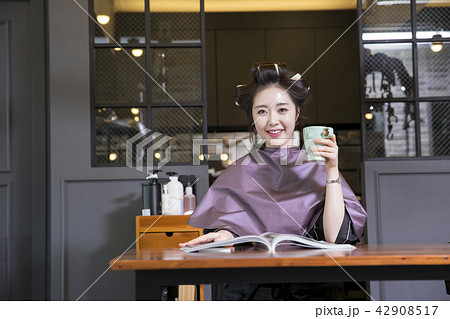 Hairdresser styling woman's hair in a salon. Korean beauty stock photo. 083 42908517