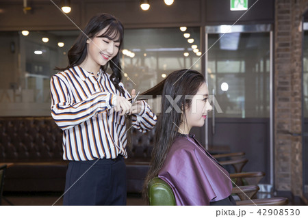 Hairdresser styling woman's hair in a salon. Korean beauty stock photo. 052 Hairdresser styling woman's hair in a salon. Korean beauty stock photo. 052 42908530