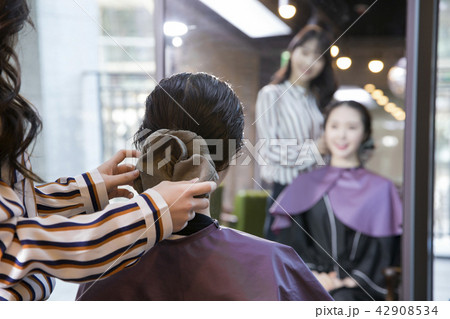 Hairdresser styling woman's hair in a salon. Korean beauty stock photo. 044 Hairdresser styling woman's hair in a salon. Korean beauty stock photo. 044 42908534