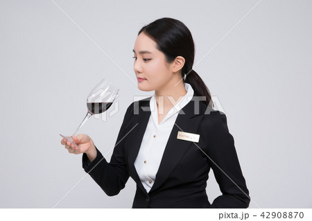 Catering services. Sommelier woman checking taste, smelling a wine isolated on white background 123 Catering services. Sommelier woman checking taste, smelling a wine isolated on white background 123 42908870